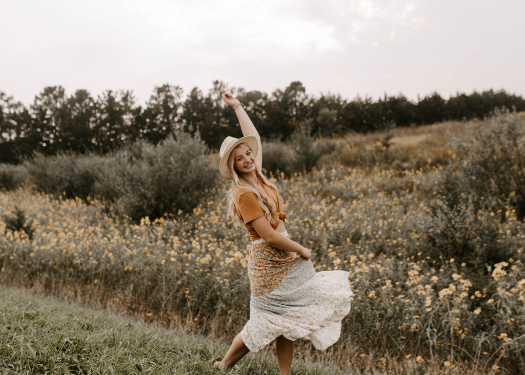 senior dancing in field of flowers